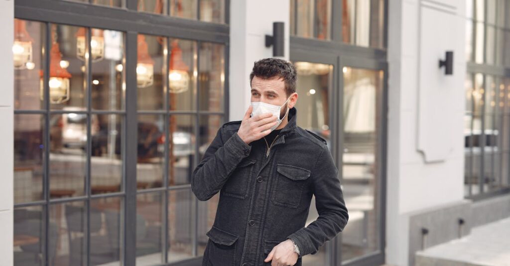 Man in black jacket wearing face mask in city reflecting pandemic normal.